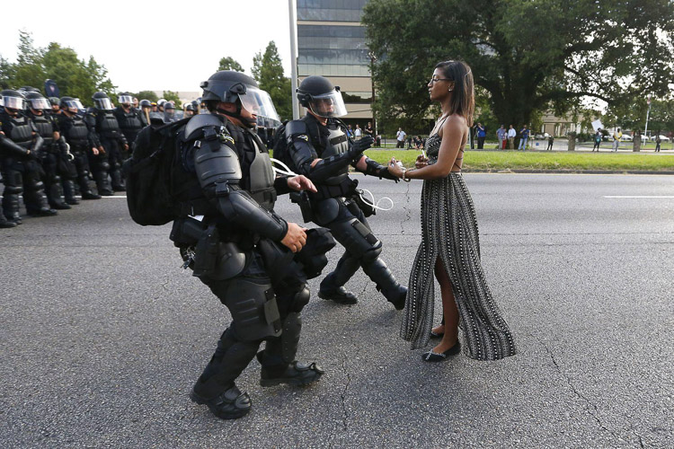 Mujer frente a la policía para que le pongan las esposas